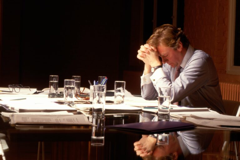 Businessman Holding Head Desk