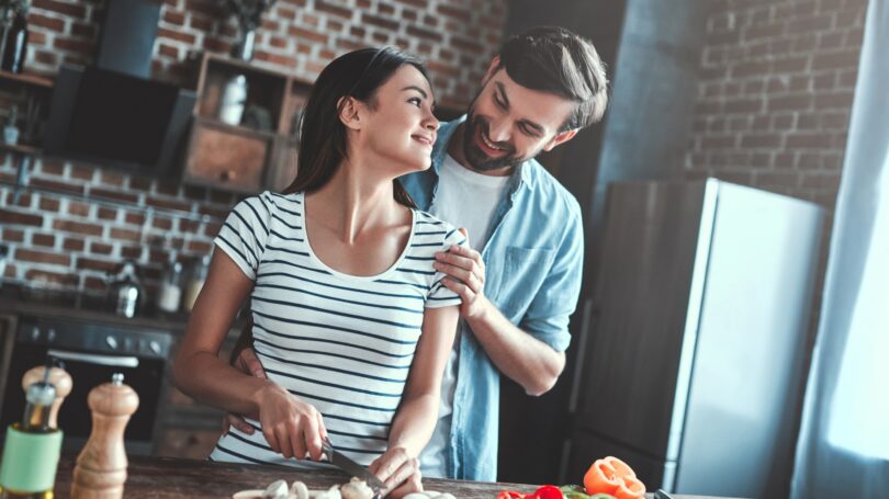 Couple Cooking Dinner Chopping Vegetables At Home