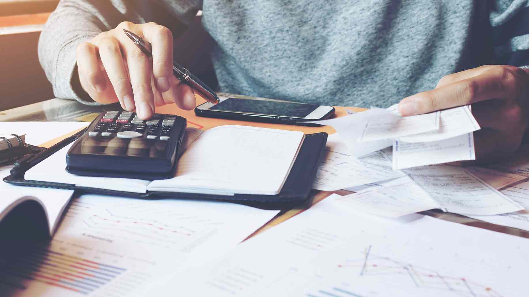 man using calculator to calculate bills 