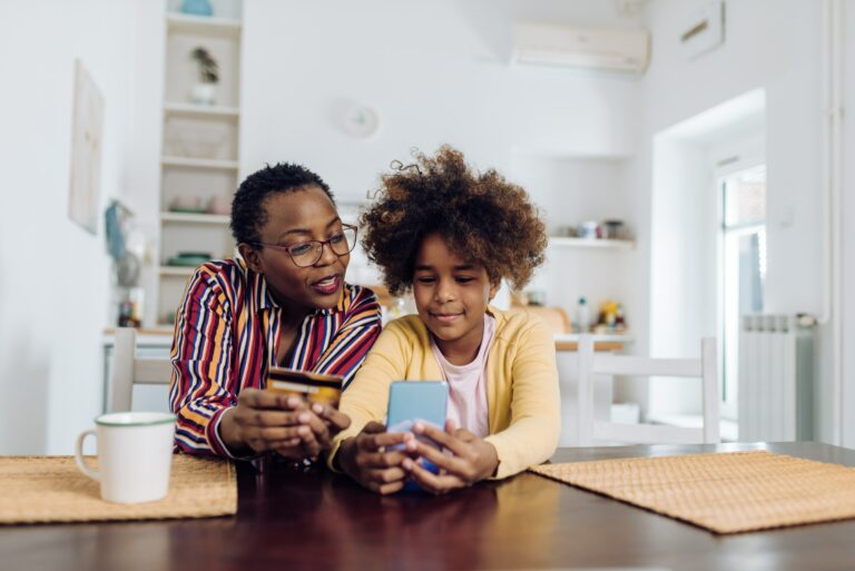 Mother Daughter Holding Phone And Credit Card